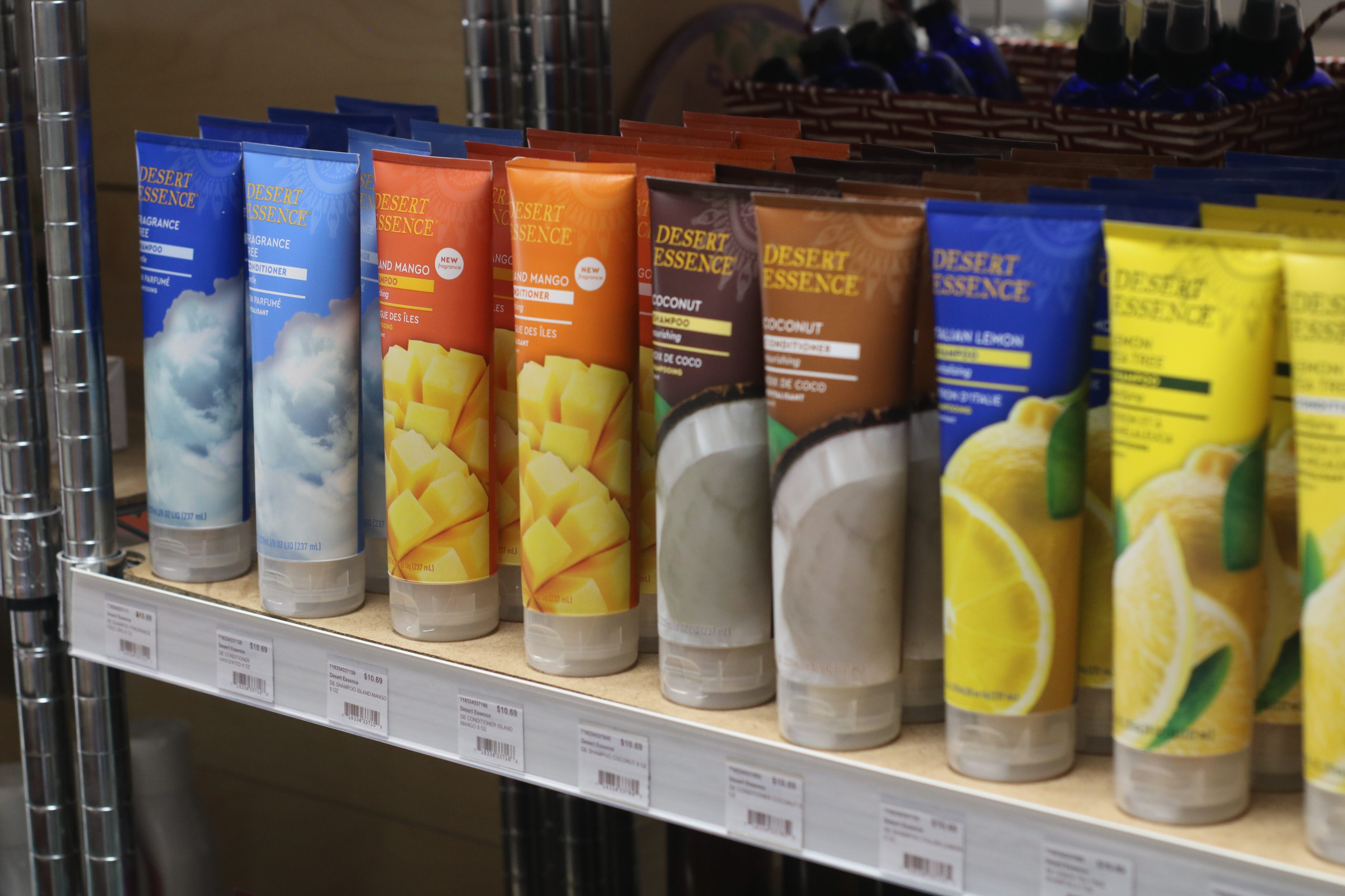 A row of assorted powdered drink mix containers on a shelf.