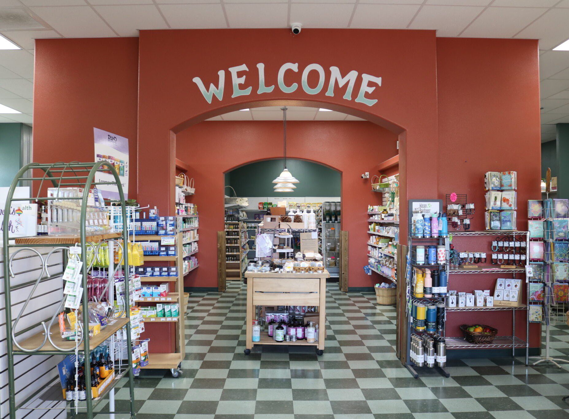 Bookstore entrance with a welcoming sign and shelves of books.