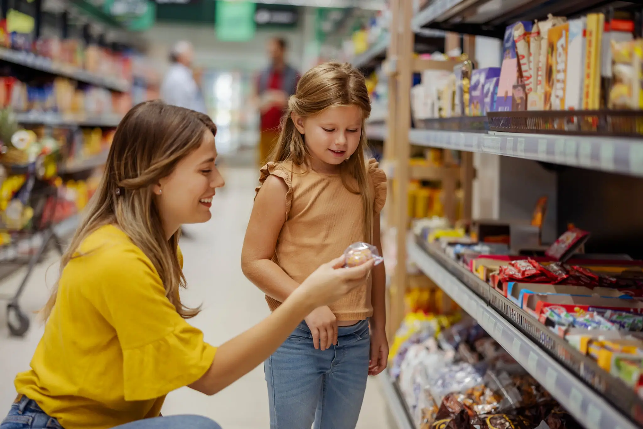 Mother and daughter shopping for groceries at a store.